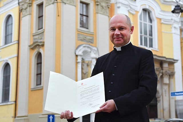 Ksiądz Stanisław Brasse pokazuje dekret Stolicy Apostolskiej.