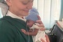 	S. Wiktoria Goska trzyma w rękach jedno z uratowanych niemowląt.