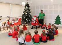 Św. Mikołaj czyta dzieciom.