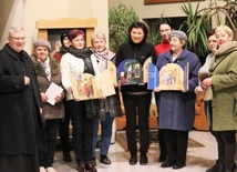 Grupa pań odbiera przygotowane przez ks. kan. Ignacego Czadera tryptyki z obrazem Świętej Rodziny.