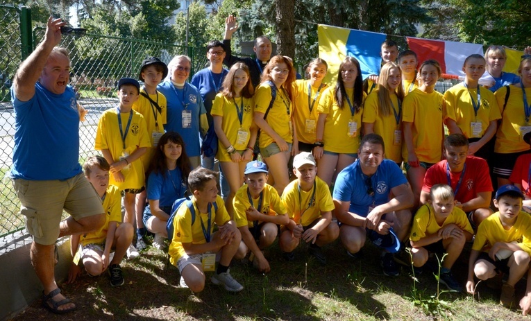 Ks. Kowalczyk (w górnym rzędzie) z kadrą i uczestnikami letniego obozu, jaki dla ukraińskiej młodzieży w lipcu 2022 roku przygotowała w Radomiu Fundacja "Dzieło Nowego Tysiąclecia".