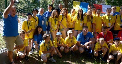 Ks. Kowalczyk (w górnym rzędzie) z kadrą i uczestnikami letniego obozu, jaki dla ukraińskiej młodzieży w lipcu 2022 roku przygotowała w Radomiu Fundacja "Dzieło Nowego Tysiąclecia".