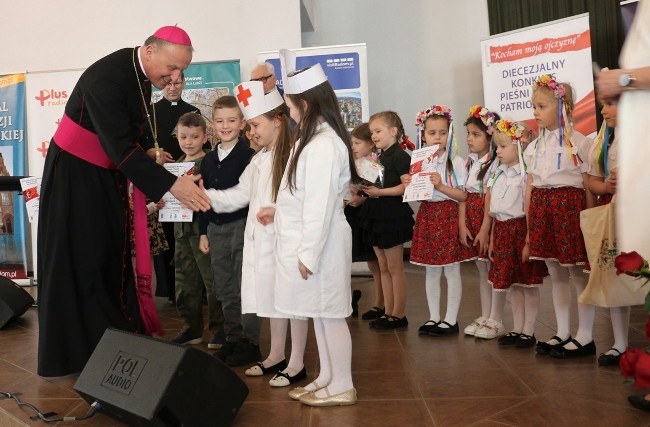 Nagrodę zespołowi Patriotyczne Zajączki wręcza bp Marek Solarczyk.