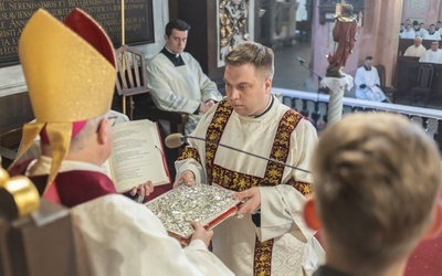 Diakoni przyjęli z rąk biskupa księgę Pisma Świętego.