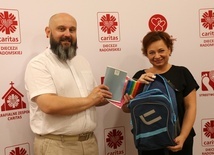 Ks. Damian Drabikowski i Iwona Stępniewska zachęcają do przekazywania przyborów szkolnych.