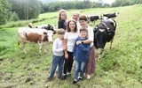 Rodzina Michurów, a za nimi krowy.