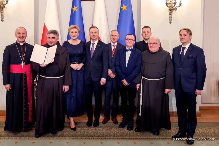 Gwardian radomskiego klasztoru z dumą pokazuje prezydencki dokument.