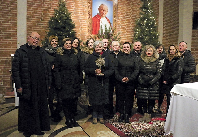 ▲	W prezbiterium kościoła przy portrecie papieża i z jego relikwiami.