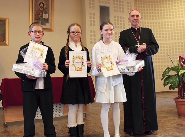 	Bp Andrzej Iwanecki i laureaci (od lewej): Jan Markefka, Małgorzata Ulitzka i Anastazja Mroncz.