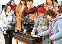 Prowadzący zaprosił uczestników do symbolicznego wrzucenia ziarna w glebę na znak wejścia w rekolekcje.