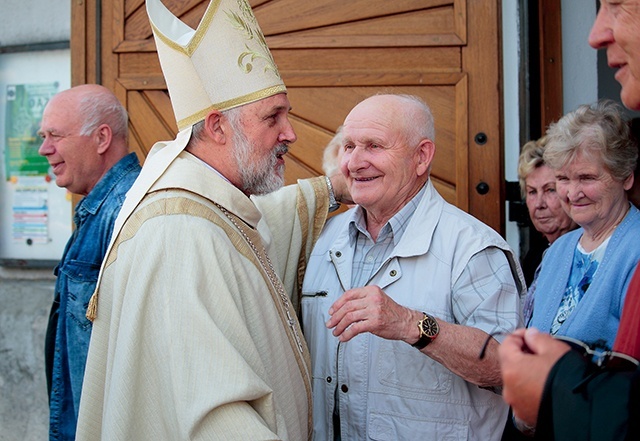 Gość z Papui-Nowej Gwinei pozdrawia wiernych wychodzących z kościoła po Mszy św.