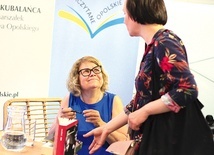 ▲	Autorka (z lewej) podpisuje swoją książkę podczas spotkania w WBP w Opolu.