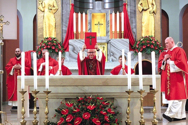 	Bp Waldemar Musioł błogosławi uczestników Ewangeliarzem. 