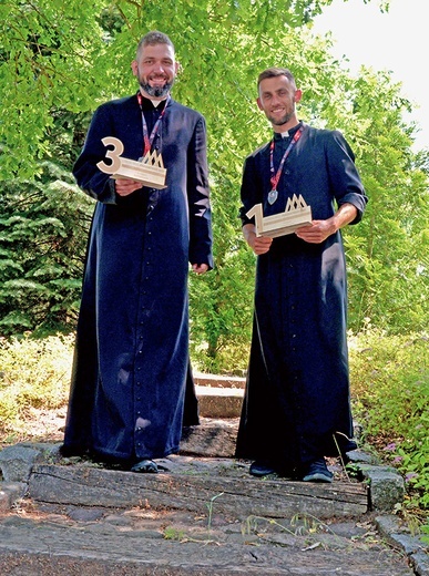 	Ks. Wojciech Pawłowski (z prawej) i ks. Kamil Jan Kowalski z medalami  i statuetkami.