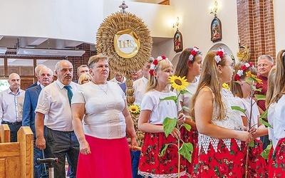 Symbol dożynkowy wniesiono do świątyni w barwnym korowodzie.