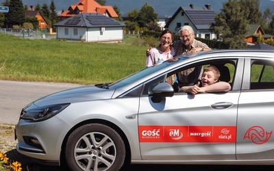 Kuba siedzi za kierownicą, a obok samochodu firmowego „Gościa” stoją mama Beata i tata Bartek.