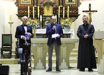 Prezentacja publikacji (od lewej): prowadzący koncert Piotr Hankus, Paweł Wilk i ks. Krzysztof Grzegorczyk, proboszcz koszęcińskiej parafii NSPJ.