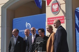 Przed tablicą  z nową nazwą uczelni  jej rektor prof. Sławomir Bukowski (trzeci od lewej).