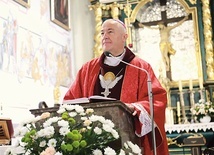 Biskup w kościele kolegiackim. W tle ufundowany przez archidiakona Stanisława Cetnarskiego po pożarze  ołtarz z Ukrzyżowanym.