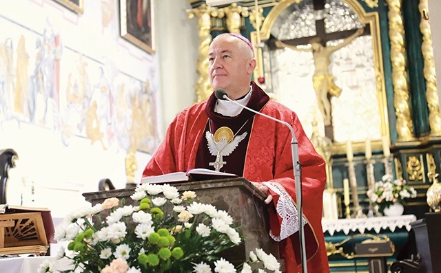 Biskup w kościele kolegiackim. W tle ufundowany przez archidiakona Stanisława Cetnarskiego po pożarze  ołtarz z Ukrzyżowanym.