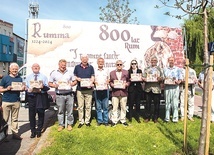 	Członkowie SKO 800 na tle billboardu promującego obchody.