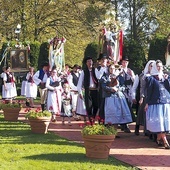 	Parafianie podczas procesji eucharystycznej wokół zabytkowej świątyni.