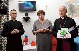 	Bp Marek Solarczyk ze świąteczną kartką, którą dostał od dzieci, obok Bożenna Pacholczak i ks. Krzysztof Andaś.