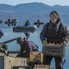 Rybak niesie skrzynię  pełną ryb po połowach w jeziorze Dojran. 1.02.2024 Dojran, Republika Macedonii Północnej