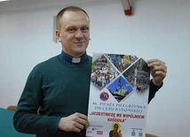 Ks. Krzysztof Bochniak prezentuje plakat pielgrzymki na Jasną Górę.