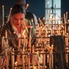 Kobieta zapala świece w sanktuarium Matki Boskiej el Rocío de Huelva w Andaluzji. 28.05.2023 Almonte, Hiszpania