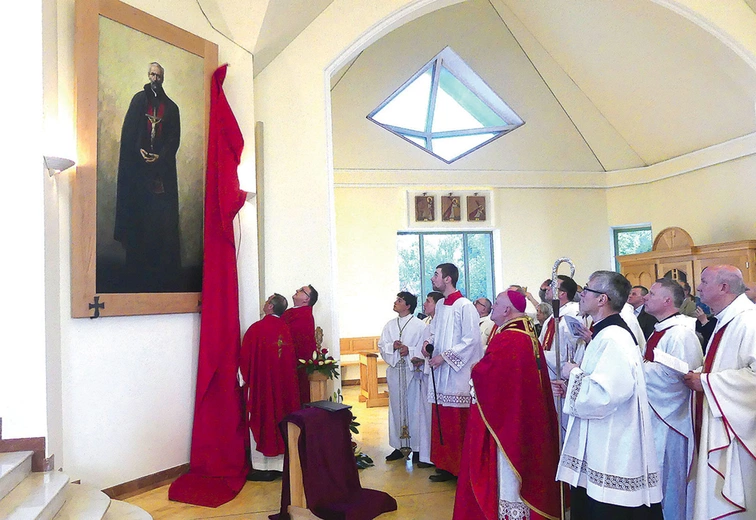 Ks. proboszcz Piotr Bieniek i ks. prof. Jacek Nowak odsłaniają obraz w Bielsku-Białej.