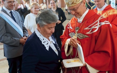 	Biskup Sławomir Oder wręcza odznaczenie Róży Schlisch