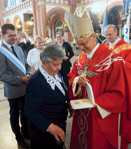 	Biskup Sławomir Oder wręcza odznaczenie Róży Schlisch