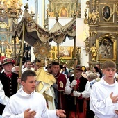 W Łowiczu wierni wychodzą za Najświętszym Sakramentem z bazyliki katedralnej.