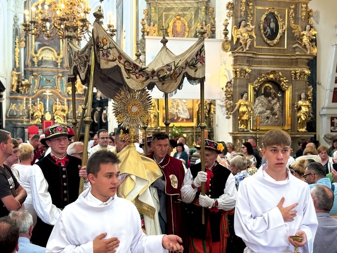 W Łowiczu wierni wychodzą za Najświętszym Sakramentem z bazyliki katedralnej.