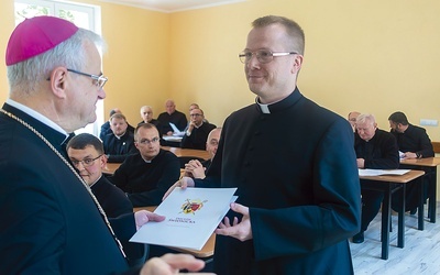 Ks. Przemysław Pojasek odbiera dokument ustanawiający go administratorem parafii św. Mikołaja w Pszennie. 