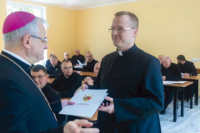 Ks. Przemysław Pojasek odbiera dokument ustanawiający go administratorem parafii św. Mikołaja w Pszennie. 