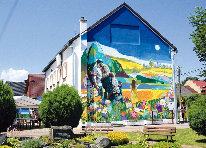 Mural opowiadający historię ekspatriacji na ścianie świetlicy.