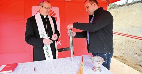 Abp Tadeusz Wojda i ks. Andrzej Wiecki umieścili podpisany akt erekcyjny w specjalnej tubie.
