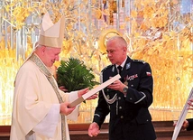 Inspektor Bogusław Zięba, komendant wojewódzki, wręczył bp. Wiesławowi pamiątkową grafikę.