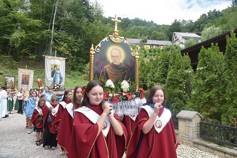 Dziewczęta ze scholi parafialnej niosą feretron z obrazem patrona.