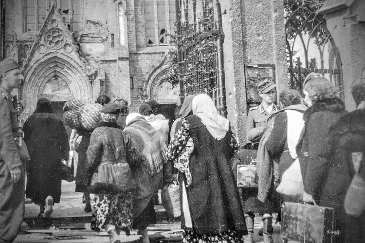 	Zdjęcie wykonane przez Karla Lehera, z zasobów Bundesarchiv, pokazuje warszawiaków pędzonych do kościoła św. Wojciecha.