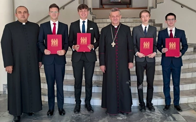 Nowi alumni z bp. Romanem Pindlem i wicerektorem ks. Jackiem Moskalem.  W rękach trzymają suscepty.