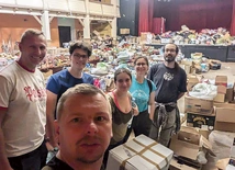 	Duszpasterz Maciejówki wraz z innymi osobami przy sortowaniu darów.