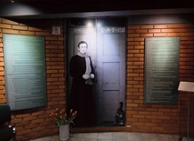 Fotografia przedstawiająca ks. Popiełuszkę autorstwa Macieja Laprusa wita wchodzących do muzeum.