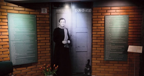 Fotografia przedstawiająca ks. Popiełuszkę autorstwa Macieja Laprusa wita wchodzących do muzeum.