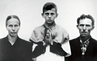 Jerzy Popiełuszko with his parents on the day of his First Holy Communion.