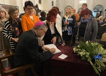 Podczas spotkania bp W. Osial podpisywał swoją publikację.