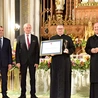 Ks. Tomasz Pastuszka, nagrodzony duszpasterz, ze statuetką i dyplomem.