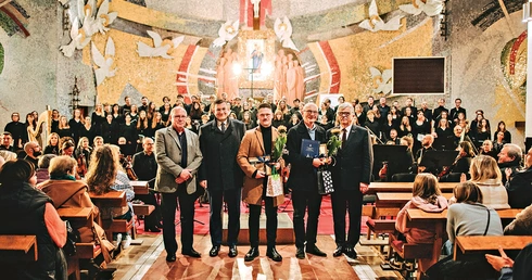 Na zdjęciu (od lewej): Daniel Ptach, dyrektor Międzynarodowego Festiwalu Muzyki Religijnej  im. ks. S. Ormińskiego, Marcin Kurkowski, sekretarz miasta Rumi, Mikołaj Gąsiewski, kompozytor, prof. Kazimierz Nowosielski, autor tekstu, oraz Kazimierz Klawiter, przedstawiciel Społecznego Komitetu Obchodów 800-lecia Rumi. W tle chórzyści i orkiestra.